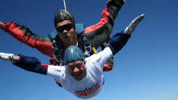 Two people attached skydiving