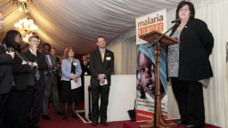 A woman addresses a room of people