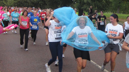 A groups of people running with one woman wearing a mosquito net